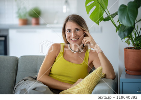 Portrait happy relaxed woman at home rest at cozy sofa smiling looking at camera. Plant lover home. Portrait happy relaxed woman at home rest at cozy sofa smiling looking at camera. Plant lover home. 119040892