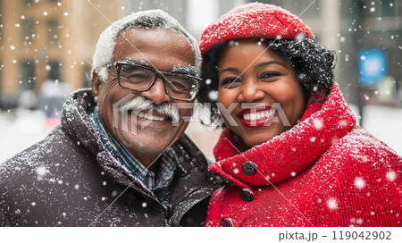 An elderly multiracial couple smiles joyfully together as snowflakes fall on Christmas Day An elderly multiracial couple smiles joyfully together as snowflakes fall on Christmas Day 119042902