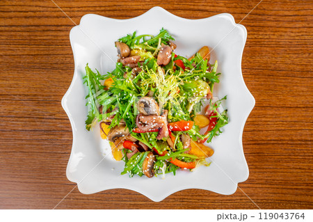 Fresh salad with seafood, baked potato and vegetables on white plate on wooden table top view Fresh salad with seafood, baked potato and vegetables on white plate on wooden table top view 119043764