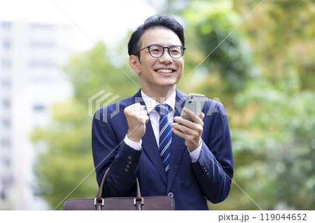 ビジネス スマホを見てガッツポーズをするミドル男性 ビジネス スマホを見てガッツポーズをするミドル男性 119044652