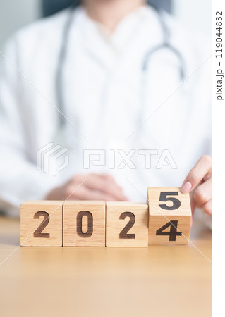 Doctor hand flipping 2024 to 2025 block. Happy New Year for Medical, Health care, Insurance and Wellness concepts Doctor hand flipping 2024 to 2025 block. Happy New Year for Medical, Health care, Insurance and Wellness concepts 119044832