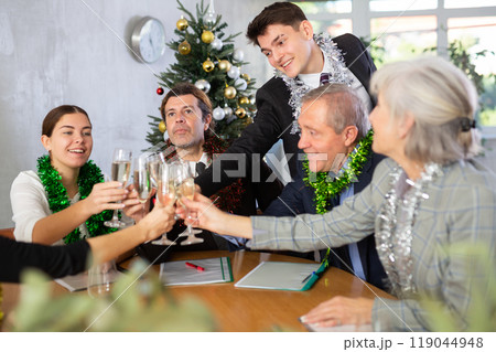 Cheerful business people celebrating New Year in coworking space Cheerful business people celebrating New Year in coworking space 119044948