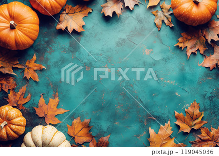 Pumpkins and vibrant autumn leaves arranged on a textured turquoise background, evoking a festive fall and Thanksgiving vibe. 119045036
