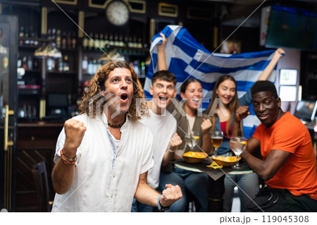 Enthusiastic Greek fans scream with joy in beer bar. Greece win 119045308