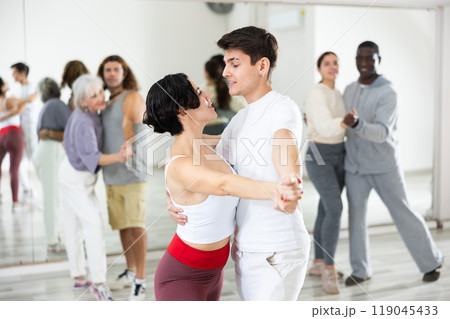 Positive couple of dancers learns a slow foxtrot Positive couple of dancers learns a slow foxtrot 119045433