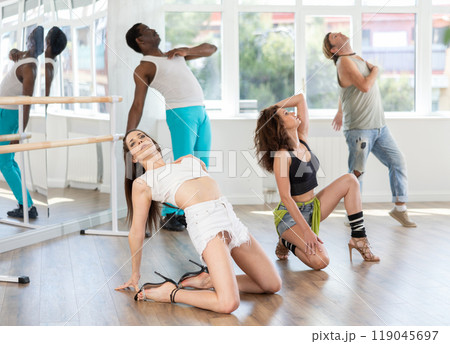 Women performing high heels choreography during group dance class Women performing high heels choreography during group dance class 119045697