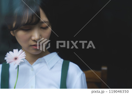 ガラス越し物憂げな表情の若い女性店員 119046350