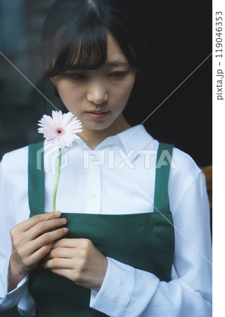 ガラス越し物憂げな表情の若い女性店員 119046353