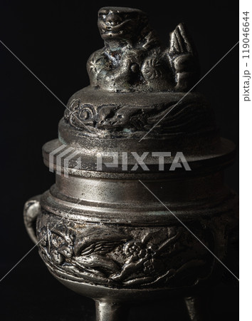 Sculpture engraved decorate on small silver ancient incense burner on dark background. Sculpture engraved decorate on small silver ancient incense burner on dark background. 119046644