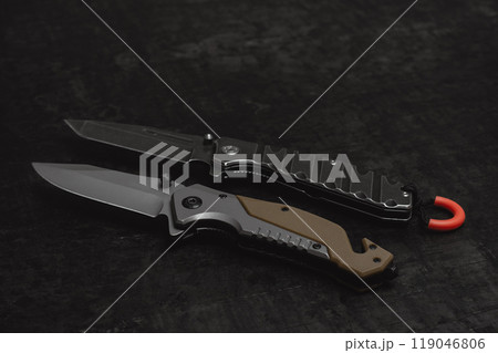 Two opened tactical military knives with sharp blade. Tool on dark concrete background. 119046806