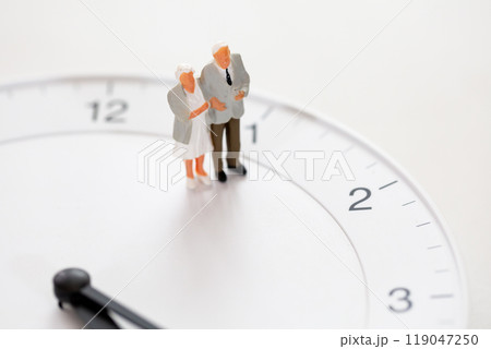 シニアライフ 老後のイメージ 時計の文字盤とシニアカップルのミニチュア 119047250