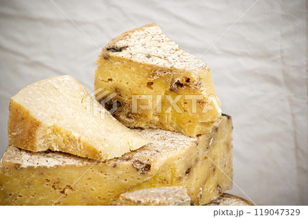 aged cheese wedges with rustic texture on white showcasing artisanal craftsmanship and rich flavor aged cheese wedges with rustic texture on white showcasing artisanal craftsmanship and rich flavor 119047329