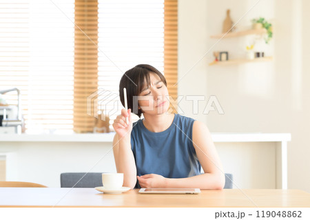 タッチペンを手に考え中の女性 119048862