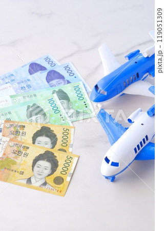 韓国の通貨、ウォンKRWの紙幣と飛行機で、韓国旅行のイメージ 119051309