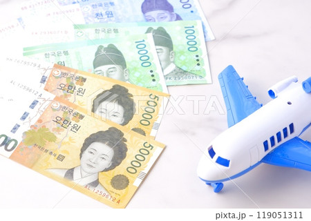 韓国の通貨、ウォンKRWの紙幣と飛行機で、韓国旅行のイメージ 119051311