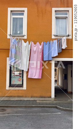 Bed linen is drying outside the window in a small courtyard of a European city. Bed linen is drying outside the window in a small courtyard of a European city. 119052603