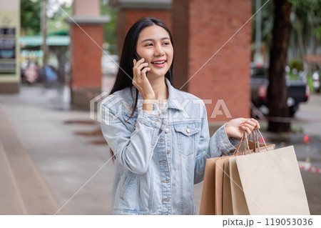 Cheerful Shopper Talking on Phone with Bags During Black Friday Sale 119053036