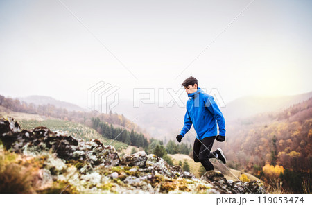 Male runner jogging in nature on dirt running trail. Morning running training for young man. 119053474