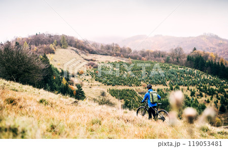 Cyclist far in the middle of beautiful nature riding down the hill. Concept of healthy lifestyle. Cyclist far in the middle of beautiful nature riding down the hill. Concept of healthy lifestyle. 119053481