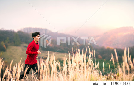 Male runner jogging in nature on dirt running trail. Morning running training for young man. 119053488