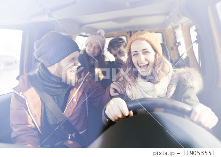 Friends going skiing at ski resort, spending the Christmas holidays together in a cabin. Driving car through a snowy landscape. Friends going skiing at ski resort, spending the Christmas holidays together in a cabin. Driving car through a snowy landscape. 119053551