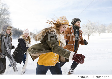 Friends in snowball fight, running and catching each other in snowy nature. First snowfall of the season. Friends in snowball fight, running and catching each other in snowy nature. First snowfall of the season. 119053567