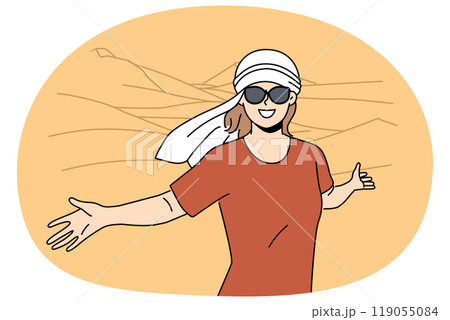 Smiling woman in headwear posing in dunes 119055084