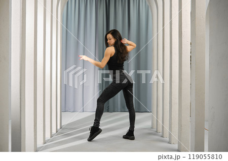 Young woman dancing in a hall with columns 119055810