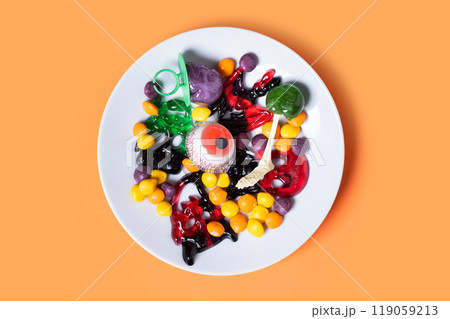 Assortment of Halloween candies on orange background 119059213