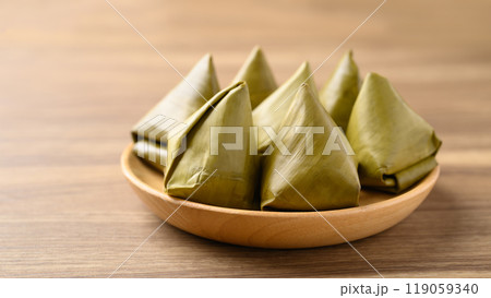 Thai dessert (Khanom Tian), Sweet dough pyramid stuffed with mung bean wrapped by banana leaf Thai dessert (Khanom Tian), Sweet dough pyramid stuffed with mung bean wrapped by banana leaf 119059340
