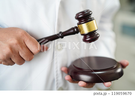 Asian doctor holding court hammer for and crime law justice, forensic medicine. 119059670