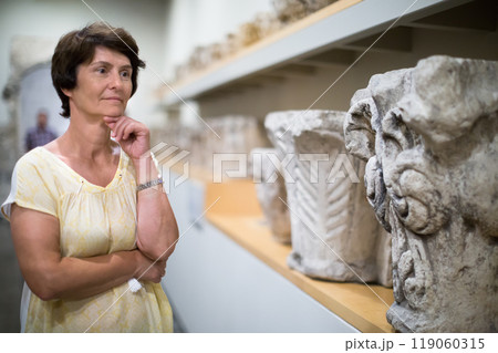 Woman examines the exhibit in historical museum 119060315