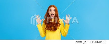 Excited, overwhelmed happy redhead cute girl in yellow sweater, screaming from joy telling about christmas gifts, showing ten fingers, order dozen products, standing joyful blue background Excited, overwhelmed happy redhead cute girl in yellow sweater, screaming from joy telling about christmas gifts, showing ten fingers, order dozen products, standing joyful blue background 119060482