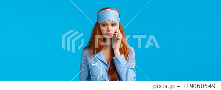Sulky and gloomy upset cute silly redhead girl calling girlfriend talking about problems, had bad dream, holding smartphone near ear, having phone call in nightwear and sleep mask Sulky and gloomy upset cute silly redhead girl calling girlfriend talking about problems, had bad dream, holding smartphone near ear, having phone call in nightwear and sleep mask 119060549