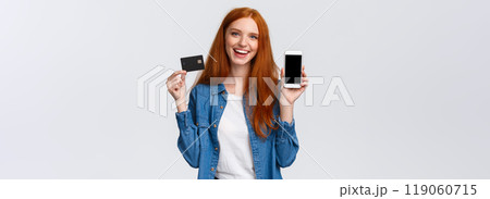 Shopping, application and mobile concept. Waist-up portrait friendly charismatic female blogger, redhead girl promote bank service, showing smartphone or app on display and credit card, smiling Shopping, application and mobile concept. Waist-up portrait friendly charismatic female blogger, redhead girl promote bank service, showing smartphone or app on display and credit card, smiling 119060715
