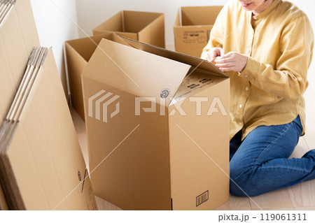 引越し用のダンボールをたくさん作るミドル〜シニア女性 引越し用のダンボールをたくさん作るミドル〜シニア女性 119061311