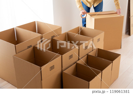 引越し用のダンボールをたくさん作るミドル〜シニア女性 引越し用のダンボールをたくさん作るミドル〜シニア女性 119061381