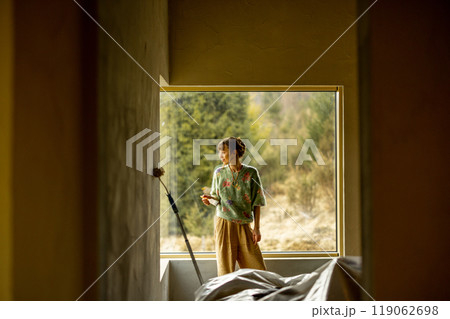 Woman paints walls while making repairment of a new house 119062698