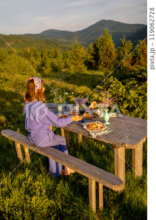 Woman decorates a table for dinner on nature Woman decorates a table for dinner on nature 119062728