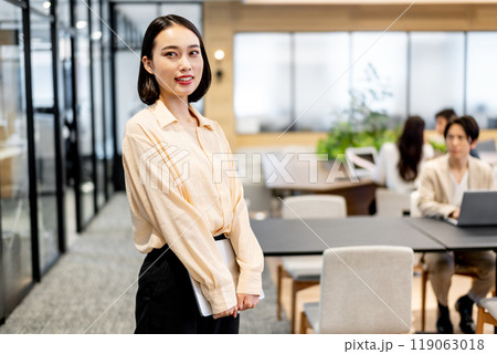 立った姿勢でノートパソコンを両手で持っているビジネスパーソン 119063018