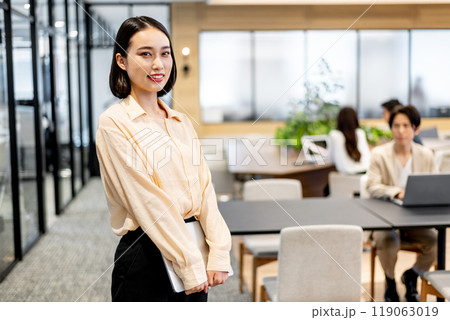 立った姿勢でノートパソコンを両手で持っているビジネスパーソン 立った姿勢でノートパソコンを両手で持っているビジネスパーソン 119063019
