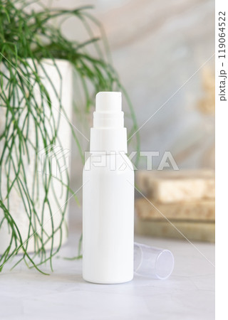 White spray cosmetic bottle on marble near green plant close up, mockup White spray cosmetic bottle on marble near green plant close up, mockup 119064522