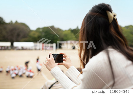 スマートフォンで運動会を撮影する女性 スマートフォンで運動会を撮影する女性 119064543