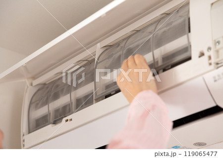 中古エアコンのフィルターを持つ女性の手元 119065477