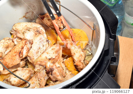 Chicken wings are turned over with tongs. 119066127