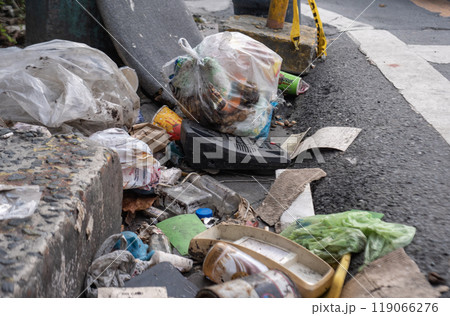 Littered street corner with garbage bags and debris Littered street corner with garbage bags and debris 119066276