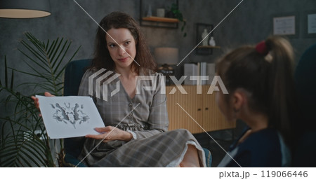 Female child psychologist shows illustrations to Asian girl during psychological test Female child psychologist shows illustrations to Asian girl during psychological test 119066446