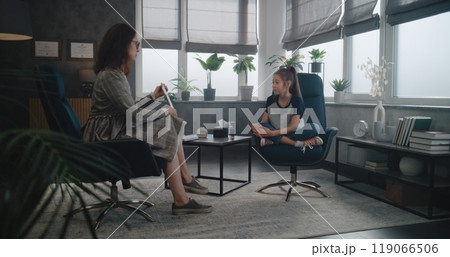 Female child psychologist shows illustrations to Asian school-aged girl Female child psychologist shows illustrations to Asian school-aged girl 119066506