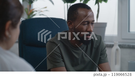 Depressed African American military man with PTSD shares feelings with psychologist Depressed African American military man with PTSD shares feelings with psychologist 119066528