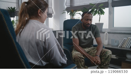 Back view of female psychotherapist providing therapy session to military man 119066530